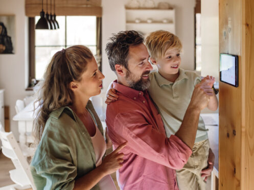 Family looking at smart thermostat